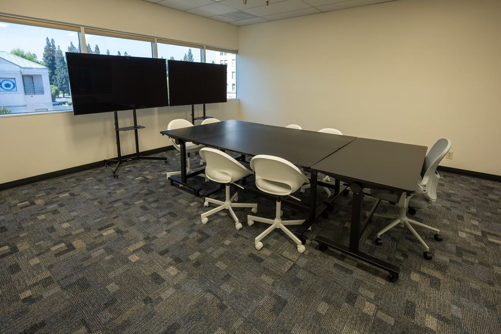 Suite B research room with a discussion table and dual screens