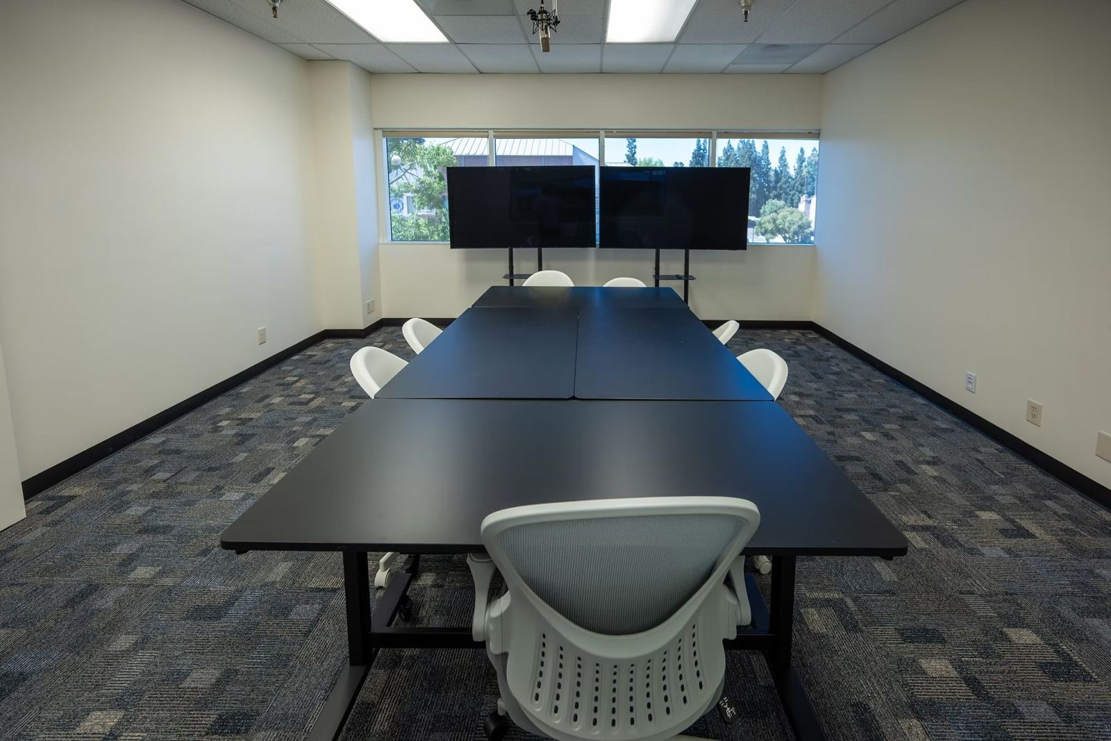Suite B discussion table facing dual screens